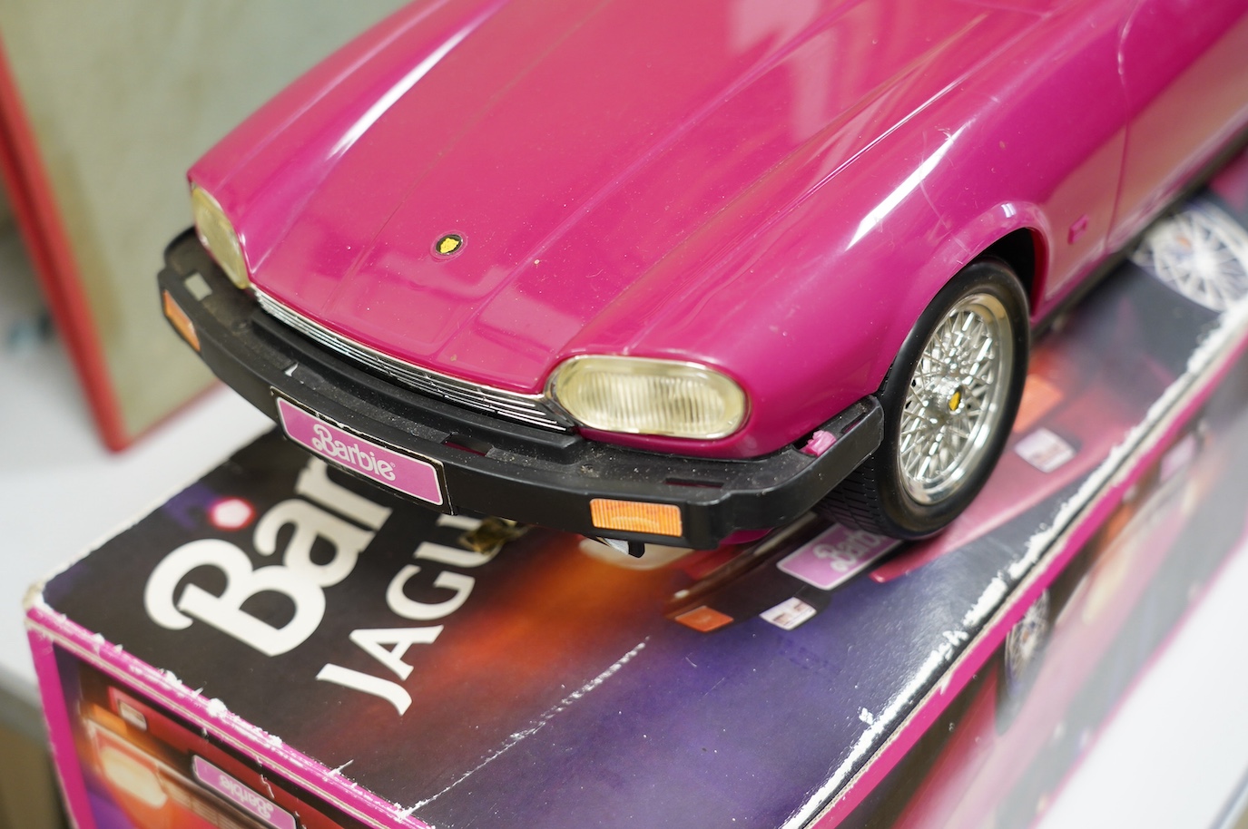 An early 1990s boxed Barbie Jaguar XJS car in pink. Condition fair to good, minor playwear and damage to the box.